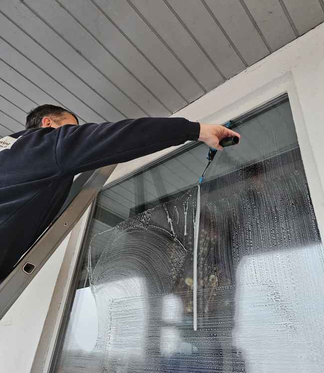 Gary pudser vinduer fra stige